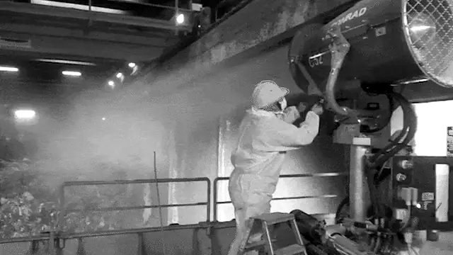 Operatore regola un cannone nebulizzatore in un impianto industriale